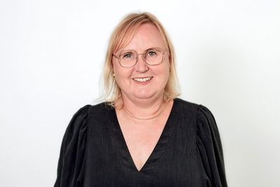 Portrait von Birgit Olbrich. Sie hat mittellange blonde Haare, trägt eine Brille und lächelt in die Kamera. Foto von Birgit Wingrat.